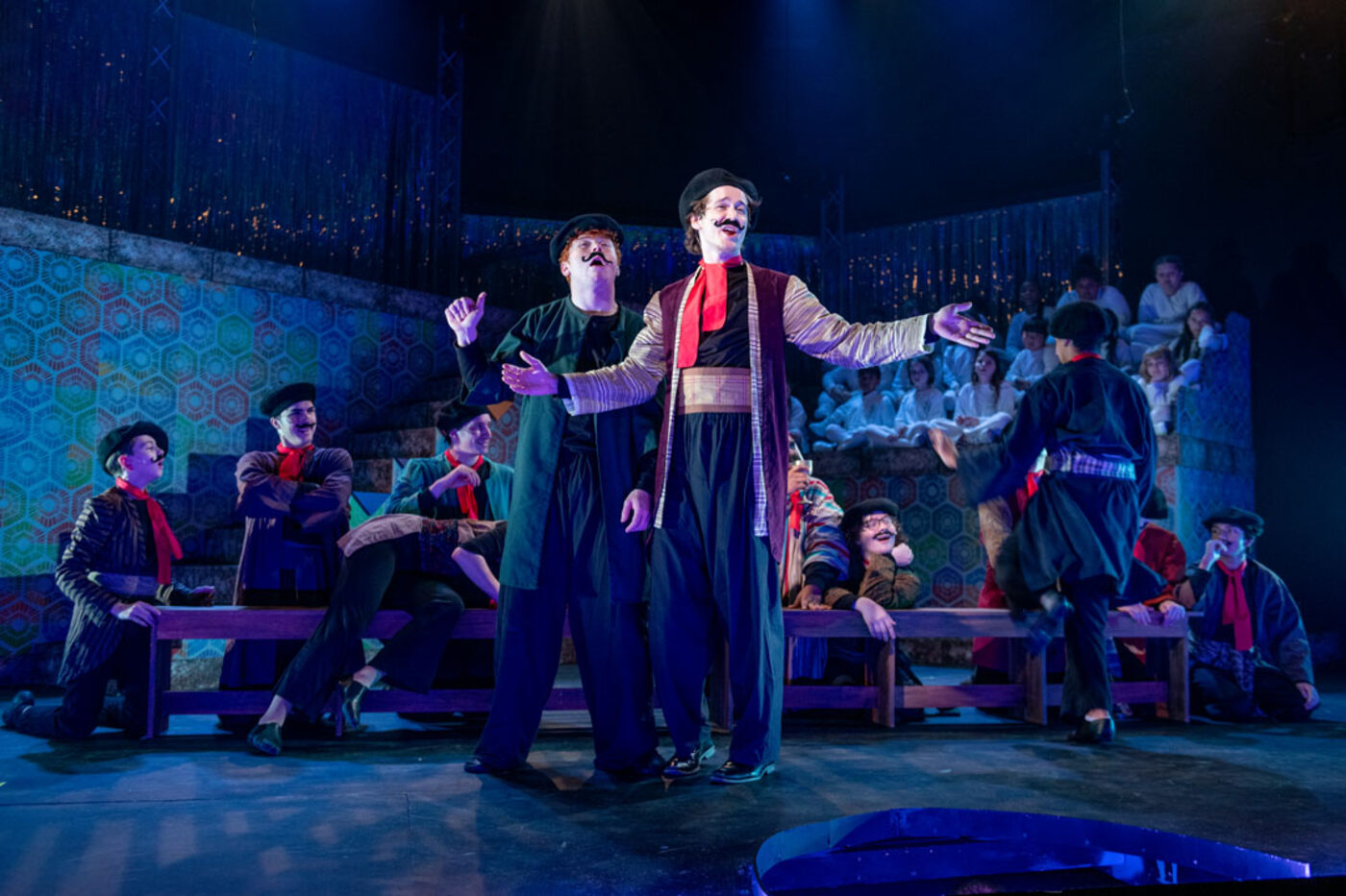 Joseph: center stage with ensemble, arms outstretched