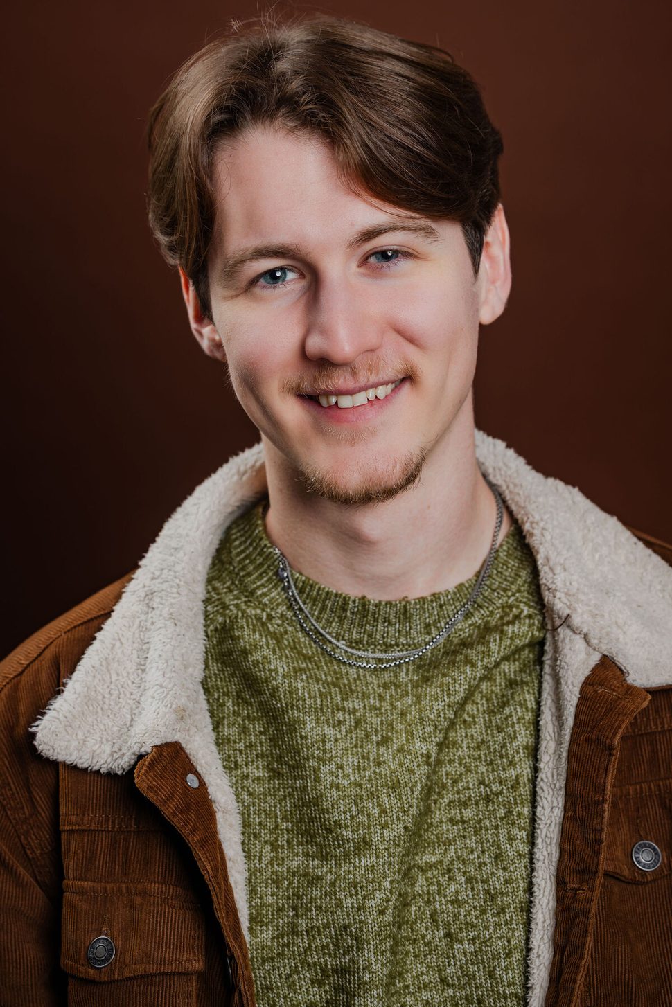 Anthony Edward, headshot — brown jacket, candid smile